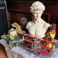 Group shot of all items including bust, clock, bookends, pencil holder, plane, car, rope horse, decanter