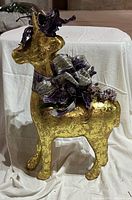 Full side view of gold reindeer with purple ribbon bow