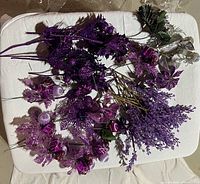Array of purple and silver glittered floral picks displayed on table