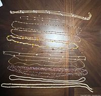 All eleven necklaces laid out to show full length, materials and colour variety