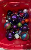 Bin containing assorted glitter plastic ornaments