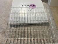 Unboxed clear acrylic organizer in front of Sonny branded box