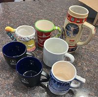 Group shot of all seven mugs and stein on countertop