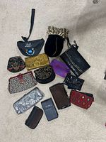 All fifteen clutches, wristlets, pouches and wallet laid out on carpet