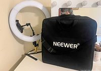 Ring light on tabletop stand beside Neewer carry bag