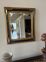 Full view of ornate gilt wood wall mirror mounted on wall