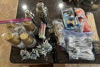 Overview of lot showing cups, utensils, shakers, picks, skewers, foil weights, napkins