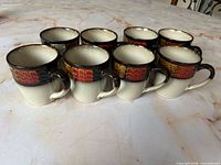 All eight Pfaltzgraff mugs upright showing exterior design