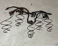 Full view of metal wine rack showing five spiral holders and vine design