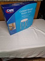 Front view of sealed Carex Compact Round Shower Stool retail box