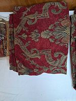 Folded red and gold damask curtain panel fabric