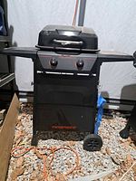 Front three-quarter view of grill showing brand logo, side shelves, wheels