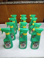 Front angled view showing 11 green spray bottles arranged on table