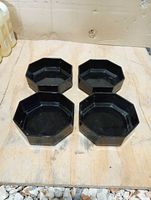 Top view of four black octagonal plastic bowls