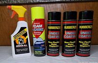 Group shot of all five products: three Rubberized undercoating cans, one Turtle Wax foam polish can, one Armor All spray bottle