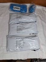 Three sealed white mailers labeled Shimmy scrub w/brush and one clear-bagged blue scrubber
