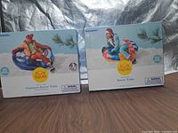 Front of both boxed Sun Squad snow tubes showing models and branding