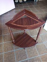Full view of triangular corner table showing both tiers and turned legs