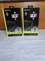 Front view of two sealed Vivitar selfie stick tripod boxes