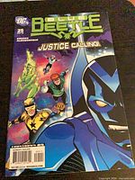 Front cover showing Blue Beetle #25 comic with characters and title