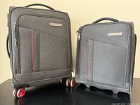 Front view of both grey Air Canada suitcases showing size difference and wheels
