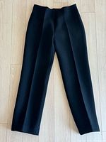 Front view of black trousers laid flat showing style and condition