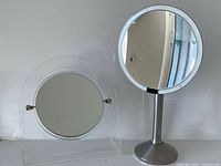 Metal stand magnifying mirror and clear acrylic mirror side by side