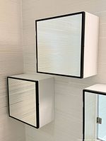 Two square mirrored wall cabinets mounted on wall