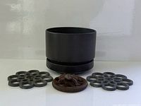 overall view of ceramic planter flanked by trivets