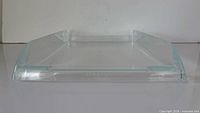 Front low-angle view of clear letter tray showing overall shape and Stratus logo