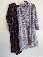 Both dresses hanging side by side showing full length and patterns