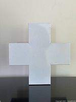 Front view of white enamel cross-shaped box closed