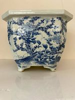 Front view of octagonal blue-and-white porcelain jardiniere showing floral transfer design and feet