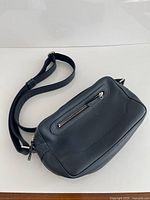 Full view of navy leather crossbody purse showing size, shape and strap