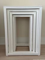 Front view of all four nested white tables