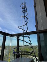 full view of metal spiral tree with lights on balcony