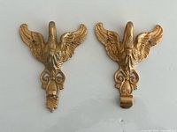 Front view of both gilt bronze swan hooks