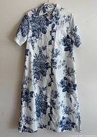 Full view of the Paul & Joe blue floral shirt dress hanging