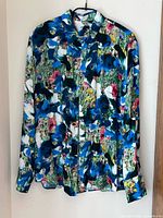 Front view of floral viscose button-down shirt hanging