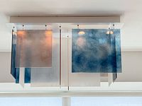 Underside view of chandelier showing canopy and lit multi-colour glass panels