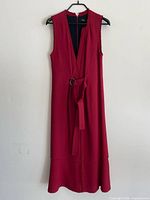 Full front view of crimson sleeveless midi dress with belt displayed on hanger
