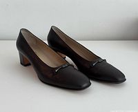 Side view of both pumps showing leather, heel style, overall condition