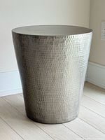 Front angled view of hammered brass stool