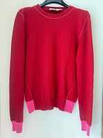 Front view of red sweater with pink trim