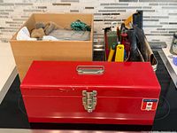 Red Mastercraft toolbox foreground, two open boxes with miscellaneous tools and hardware behind