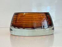 Side profile showing thick clear base and amber body