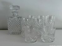 decanter with stopper alongside group of tumblers
