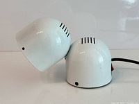 Side view showing two connected white metal spheres and lamp head