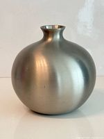 Full front view of spherical brushed stainless steel vase