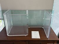 Clear acrylic Lumacryl base and glass top resting on cabinet